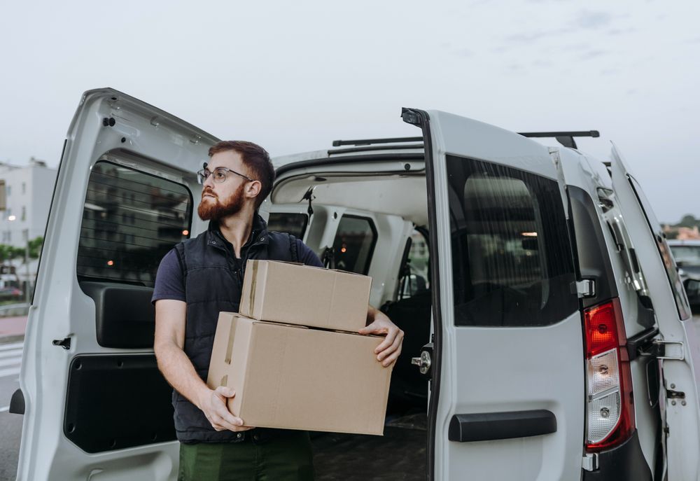 Courier taking out cartons of car for delivery completion