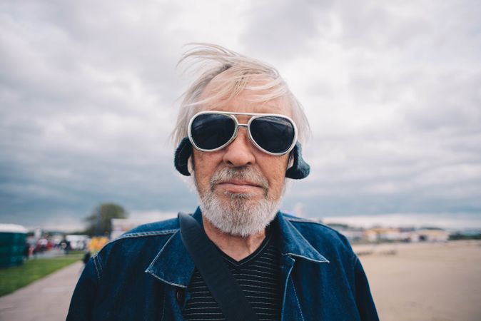 Man with gray hair and beard wearing sunglasses looking at camera