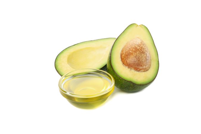 Ripe fresh avocado and oil isolated on blank background