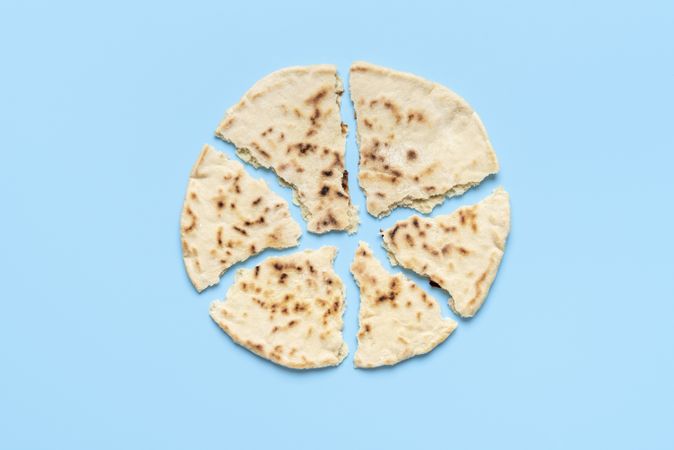 Naan bread pieces minimalist on a blue table, view from above