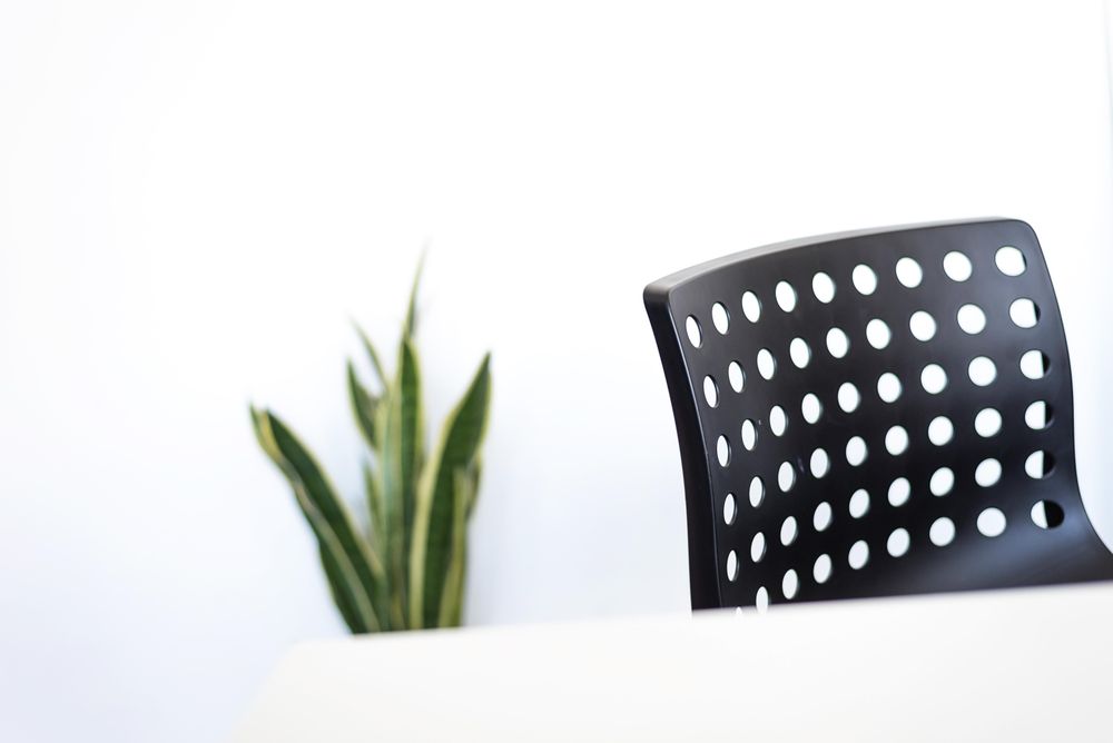 Desk with plant and dark chair