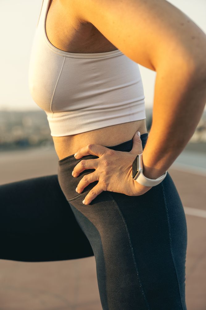 Close up of an athletic woman doing forward lunge exercise, focus on leg muscles and proper form.