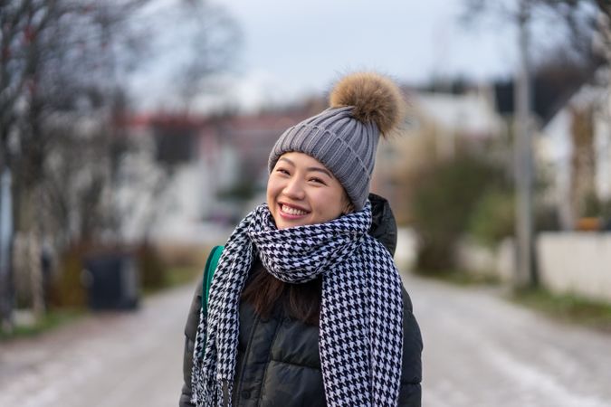 Asian female tourist in warm clothing at snowy nature