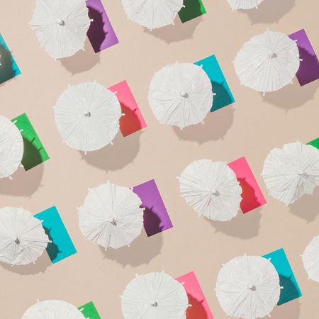 Pattern of sun umbrellas and multicolored towels in rows on sand