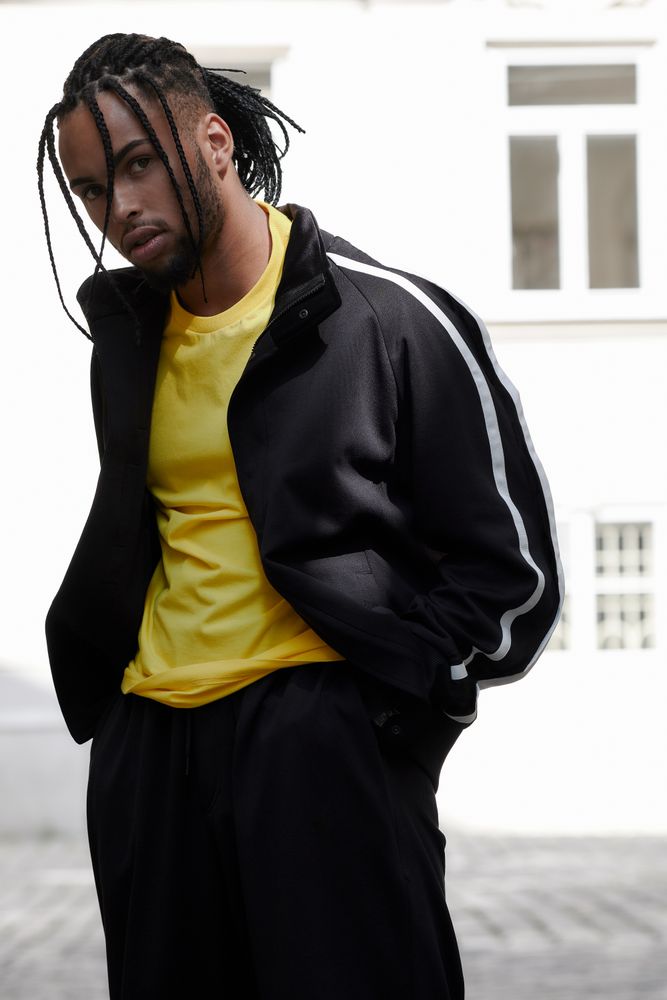 Black male standing with arms crossed
