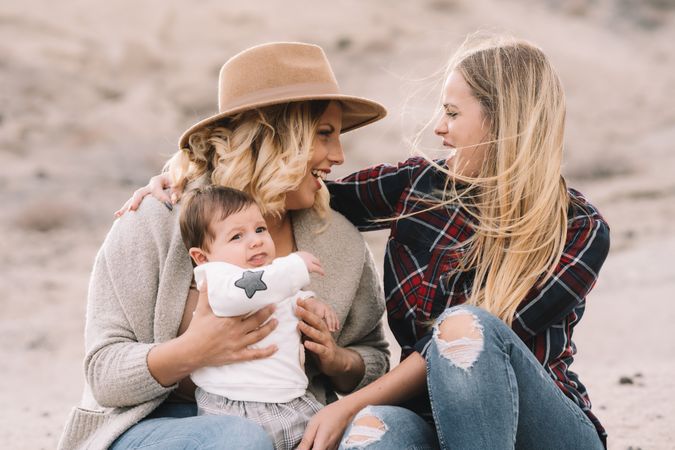 Cheerful women resting with baby on nature
