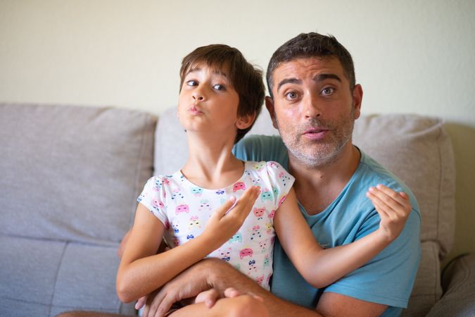 Little girl and dad joking around together at home