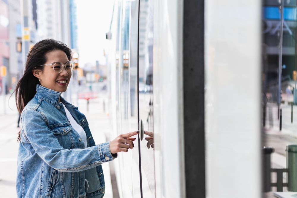Long-haired brunette Chinese woman pulling out a train ticket at the station