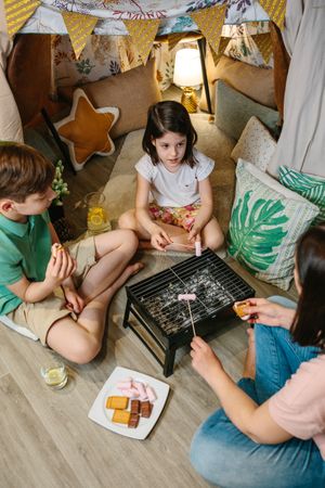 Family preparing s'mores with barbecue at home