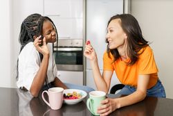Two women talking together over breakfast in the kitchen