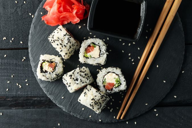 Tray with delicious sushi rolls on wooden background, top view. Japanese food