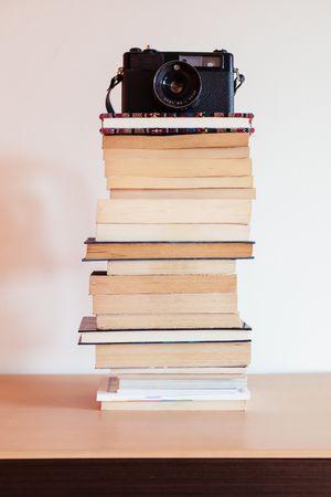 Vintage camera on top of a stack of books