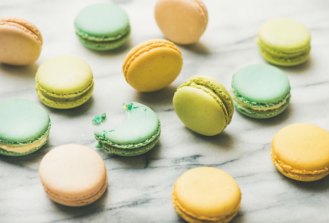 Scattered pastel macaron pastries, horizontal composition