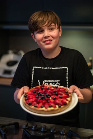 Boy holding strawberry tart