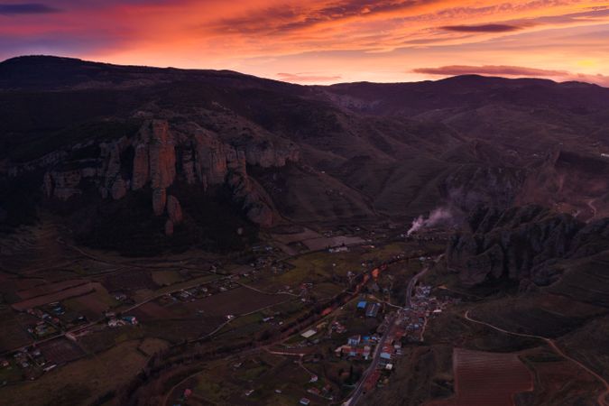 Multicoloured sunset above mountain valley and rural town