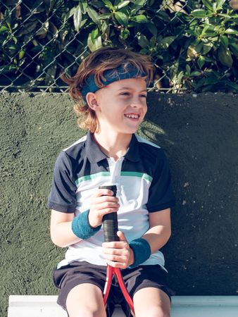 Cute preteen boy in sportswear with tennis racket