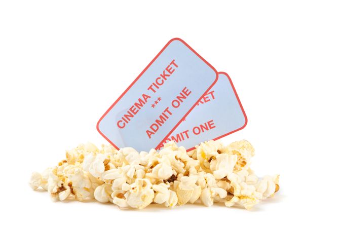Popcorn pile with tickets isolated on blank background, close up