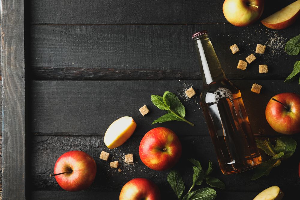Composition with cider, sugar and apples on wooden background