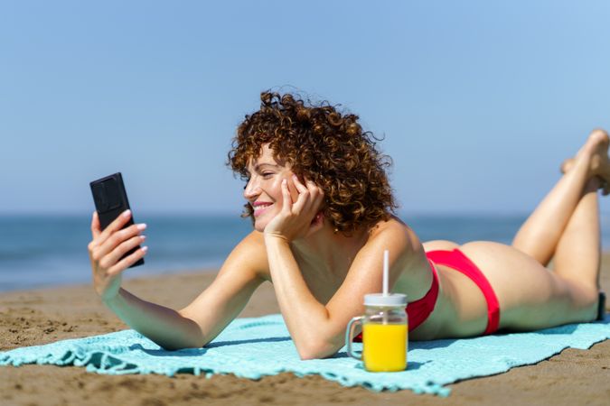 Smiling woman taking selfie on coast