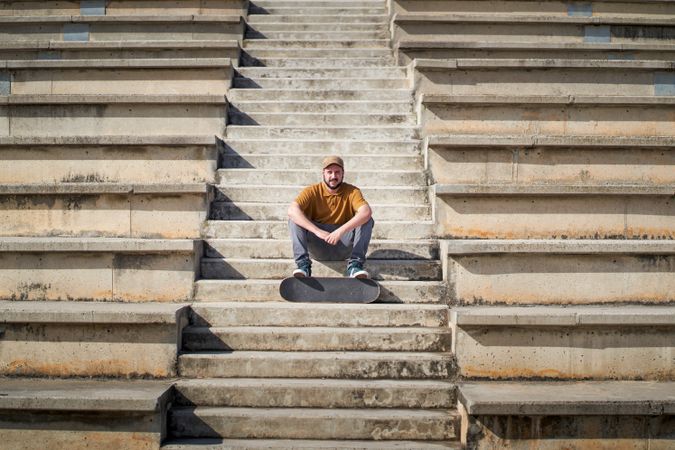 a young man sitting on some steps with his skateboard
