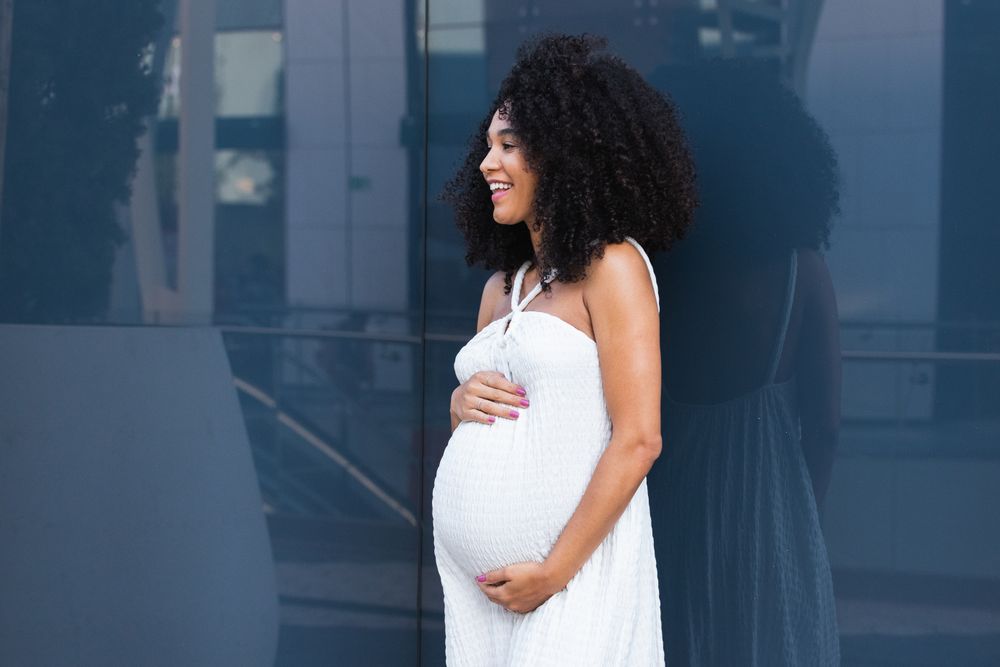 Smiling pregnant woman in long dress