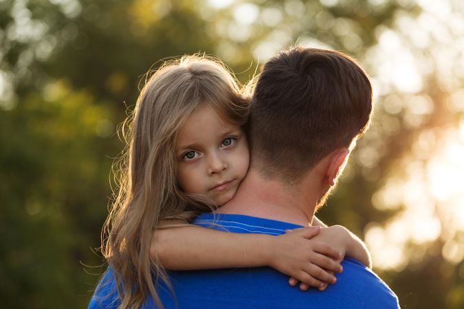 Girl hugging her dad in blue in forest