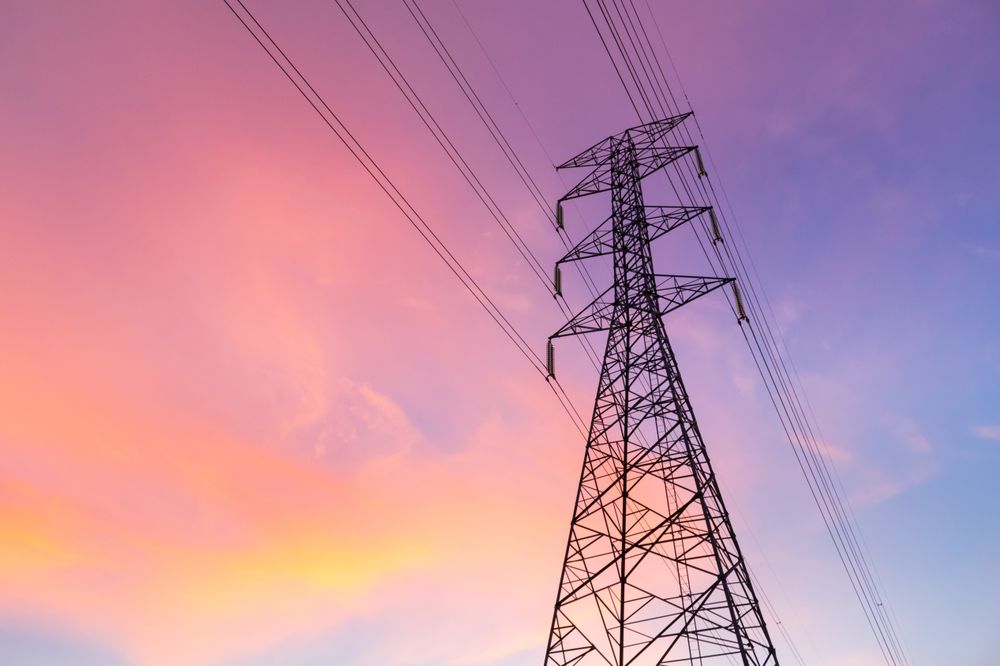 Electric Tower Against a Vibrant Sunset Sky with Colorful Clouds