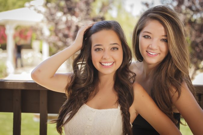 Two smiling female friends in outside garden
