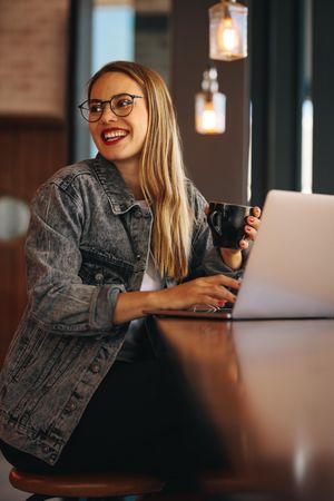 Smiling woman at a cafe with laptop