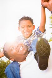 Son and Father Playing Piggyback Outdoors Together.