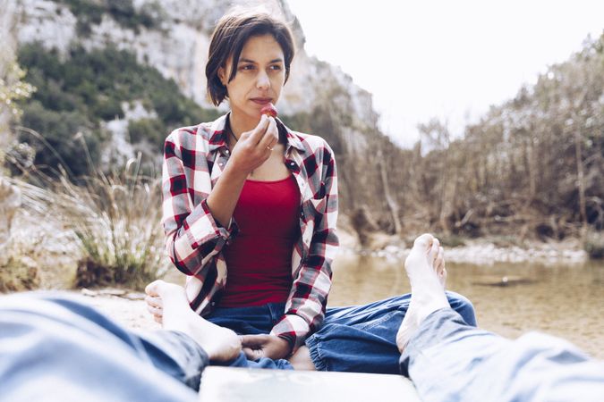 Couple spending picnic on shore in cliffs