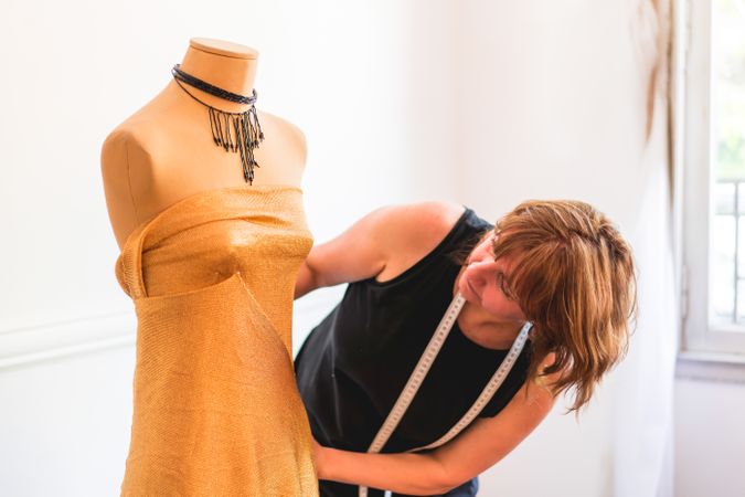 Fashion designer dressing a mannequin with garment
