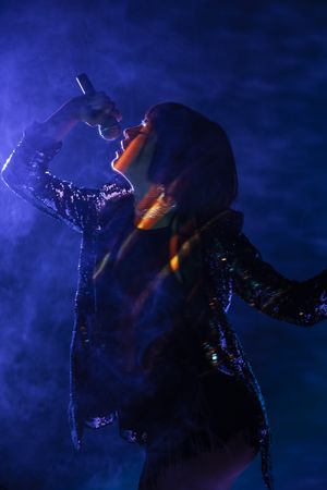 Stylish woman singing on stage