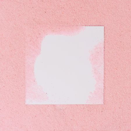 Pink sand covering parts of paper square