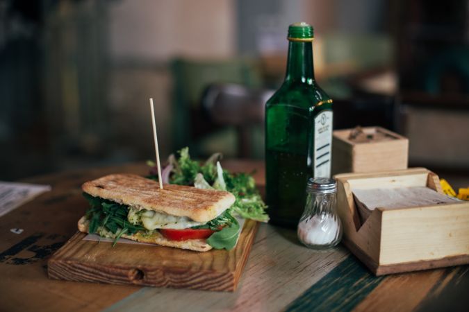 Grilled sandwich on rustic wooden board in cafe
