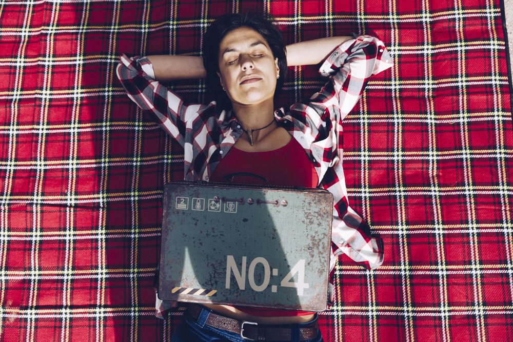 Cheerful woman with old case on picnic