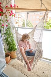 Kid sitting in hammock and writing in diary