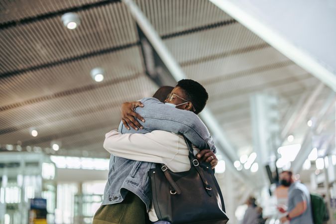Couple embracing at airport during pandemic