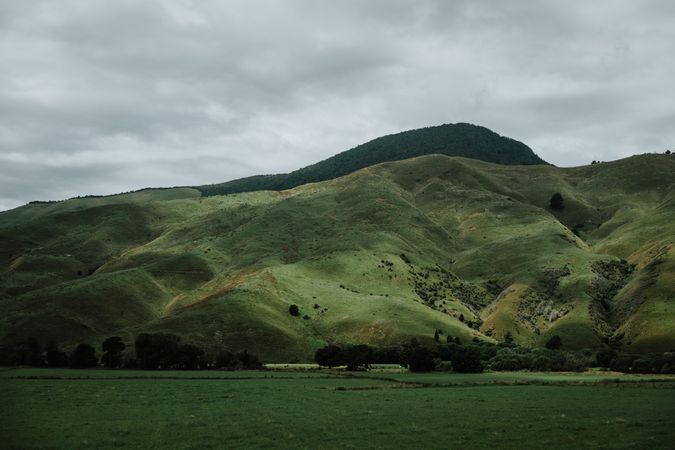 Green hills and field in cloudy day