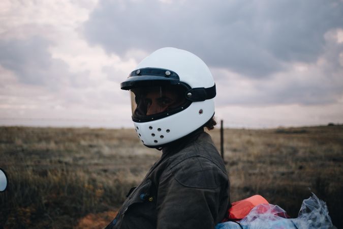 Motorcyclist in helmet with field behind him