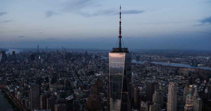 Late Evening Aerial Photo of the One World Trade Center Skyscraper with Antenna. Helicopter Flying Around the Glass Building with a View on All Five New York City Boroughs