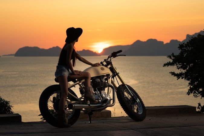 Woman with motorbike near sea