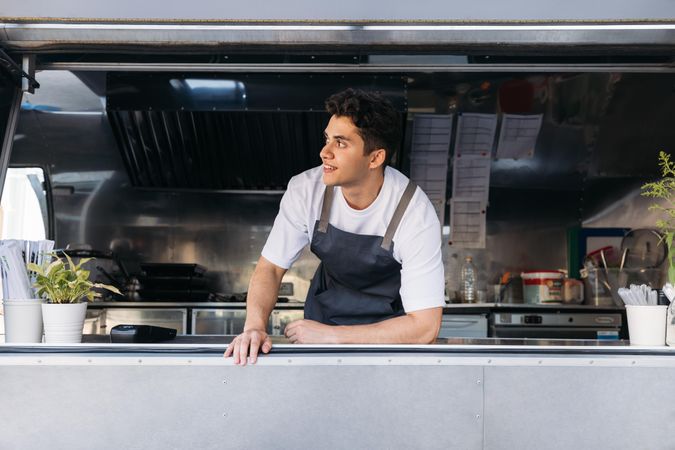 Smiling male food truck cook in open kitchen