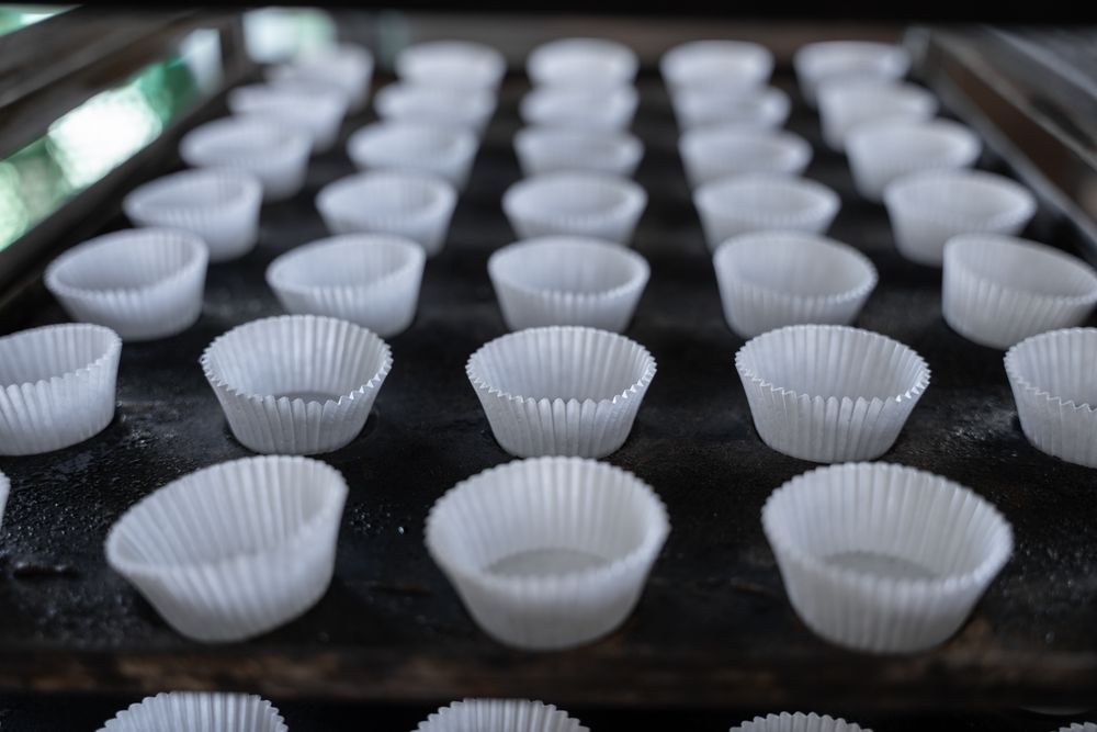 Empty cupcake mold ready to be filled on a baking tray