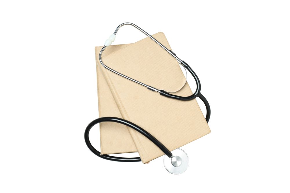Books and stethoscope, isolated on light background