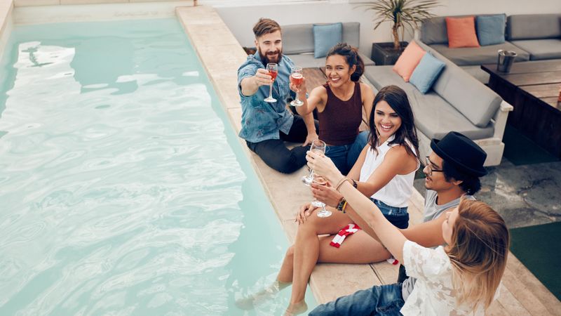 Group of multiracial friends toasting at pool party outdoor