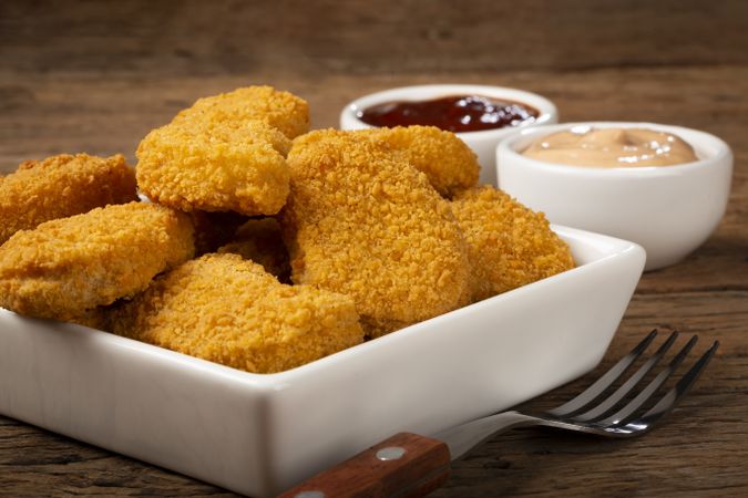 Fried chicken nuggets with ketchp and rose sauce.