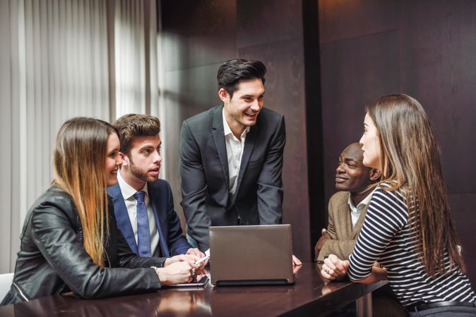 White male leading his colleagues in a meeting at work