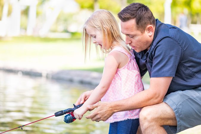 Young Father and Daughter Having Fun Fishing At The Lake