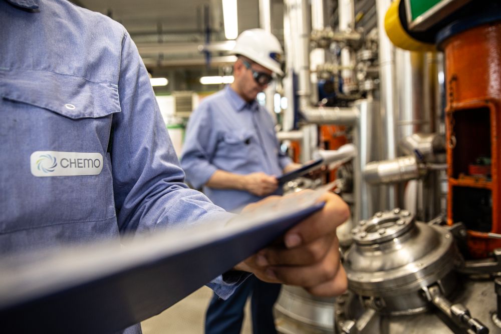 Two men with bump cap in a factory